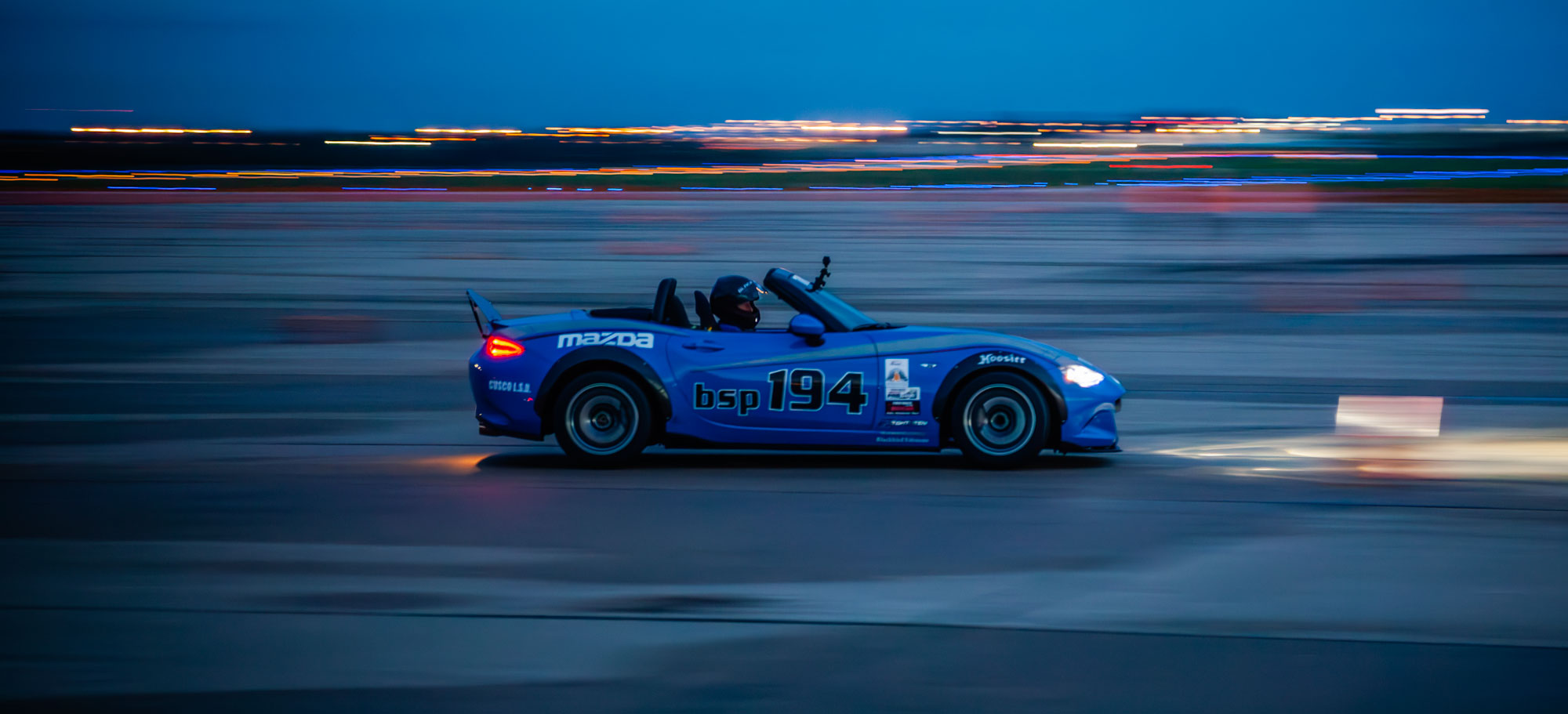 A blue Mazda Miata autocrossing in the dark at the 2018 Solo National Championships